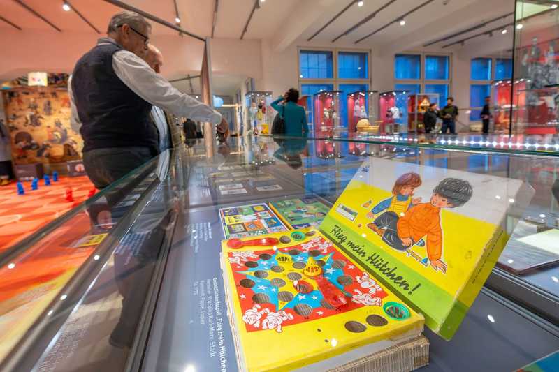 "Flieg mein Hütchen!" Spiel "Flieg mein Hütchen!" mit zwei Männern daneben