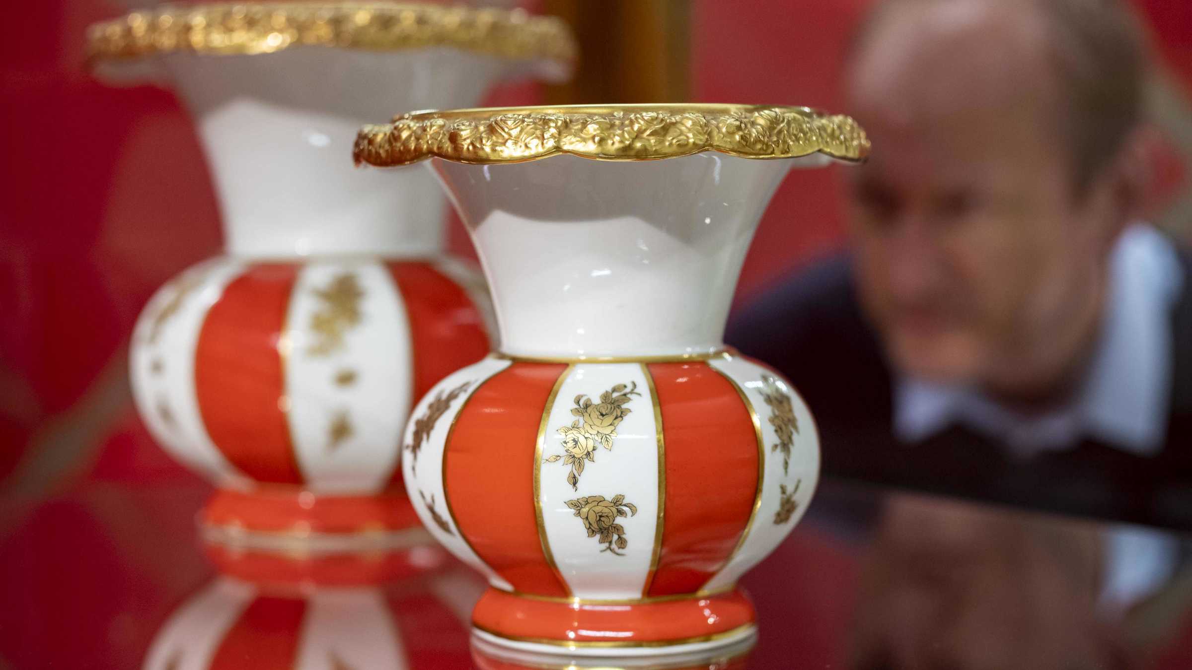 Begehrt und zerbrechlich Blick auf zwei Exponate der Ausstellung "Begehrt und zerbrechlich". Gold und Rot verziertes Porzellan.
