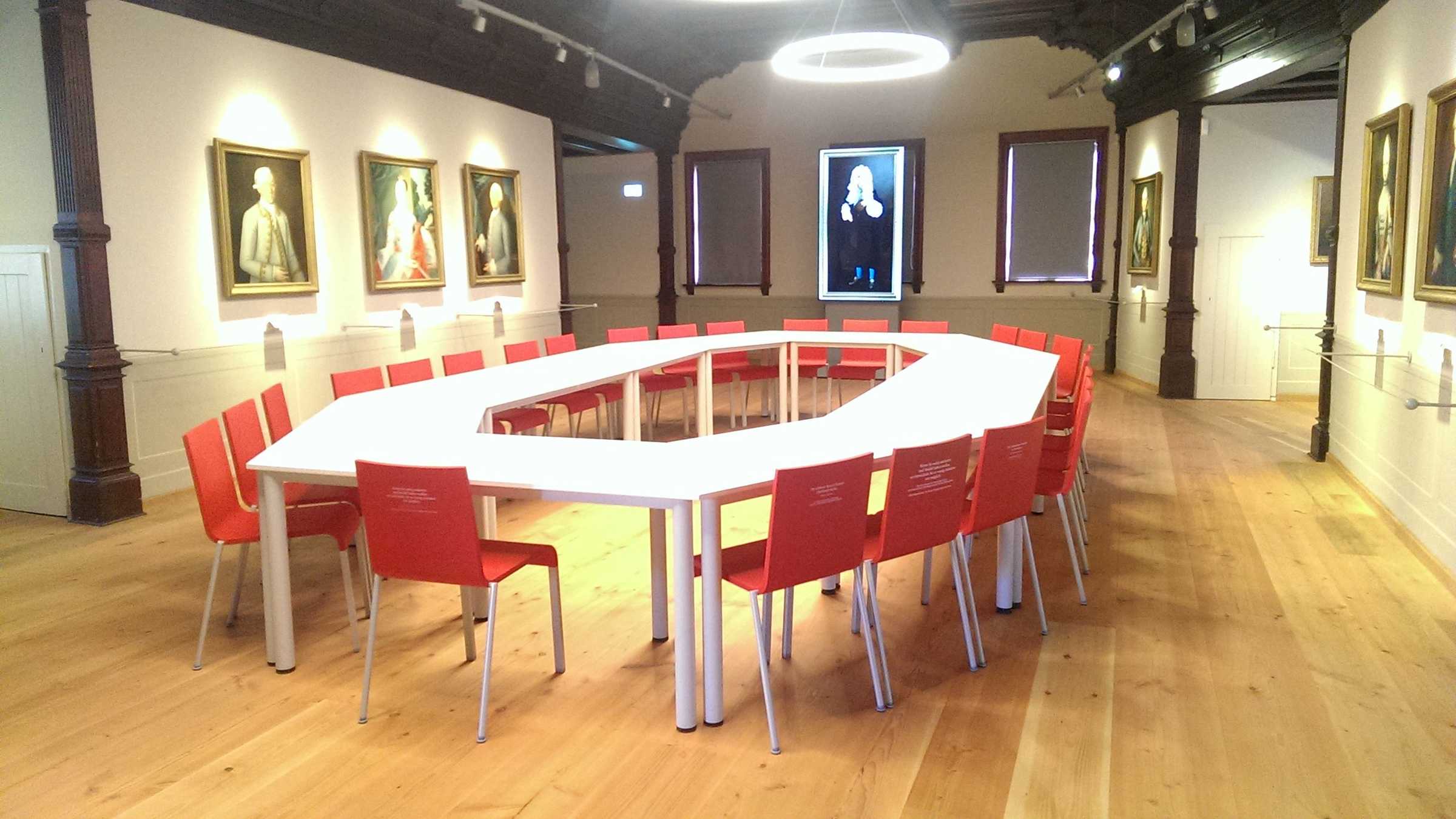Saal mit Tafel und Stühlen