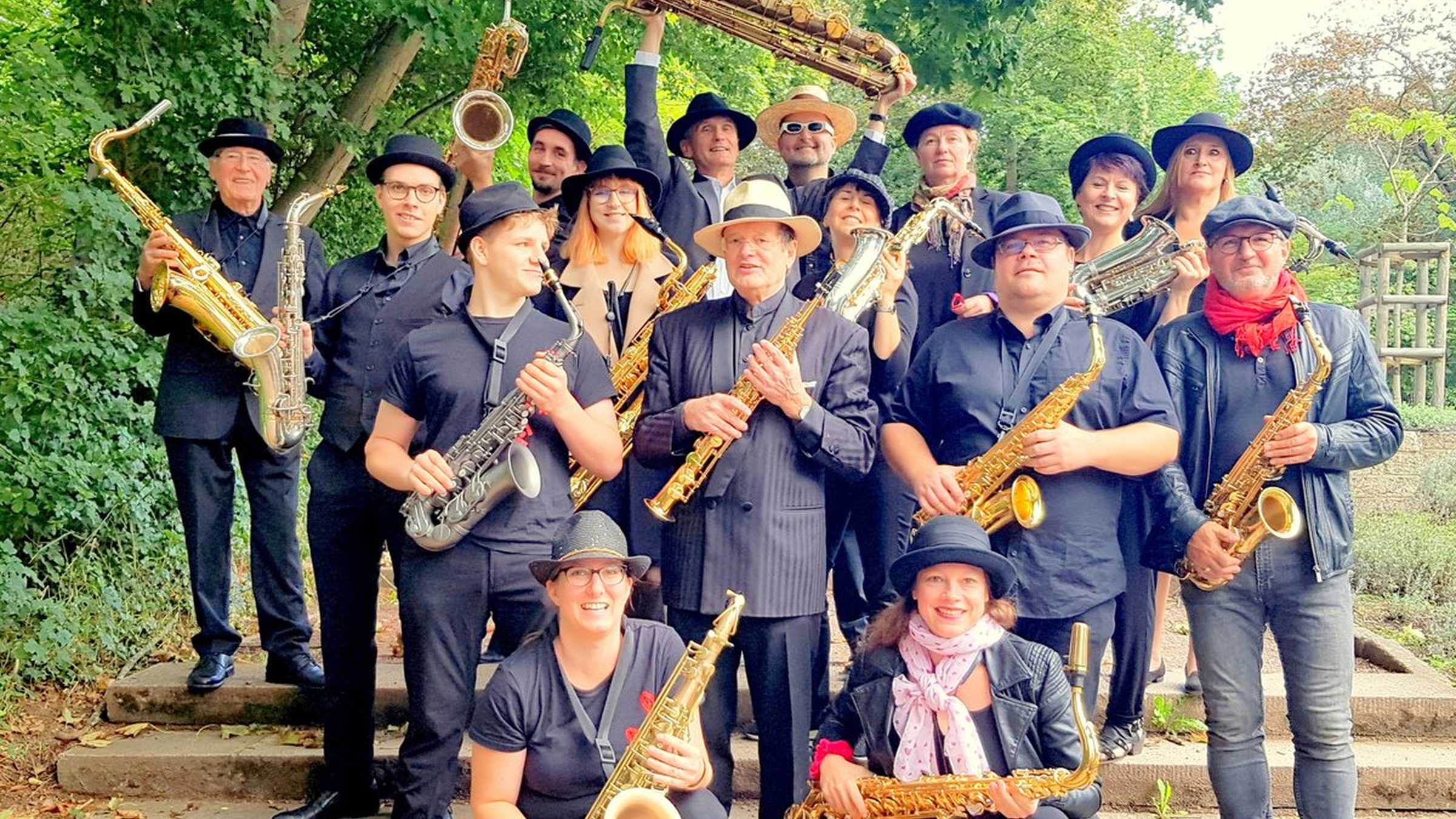 SAXLUST Gruppenbild mit 14 Bandmitgliedern mit Saxophonen auf einer Treppe