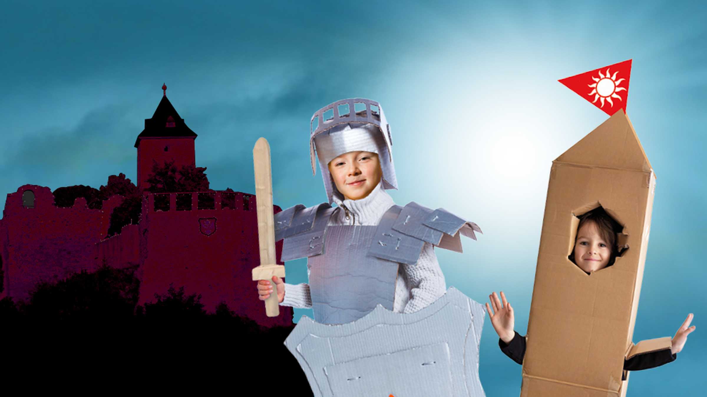 ein Mädchen in Ritterrüstung aus Pappe und ein Mädchen in einem Pappturm vor der Silhouette der Burg Giebichenstei