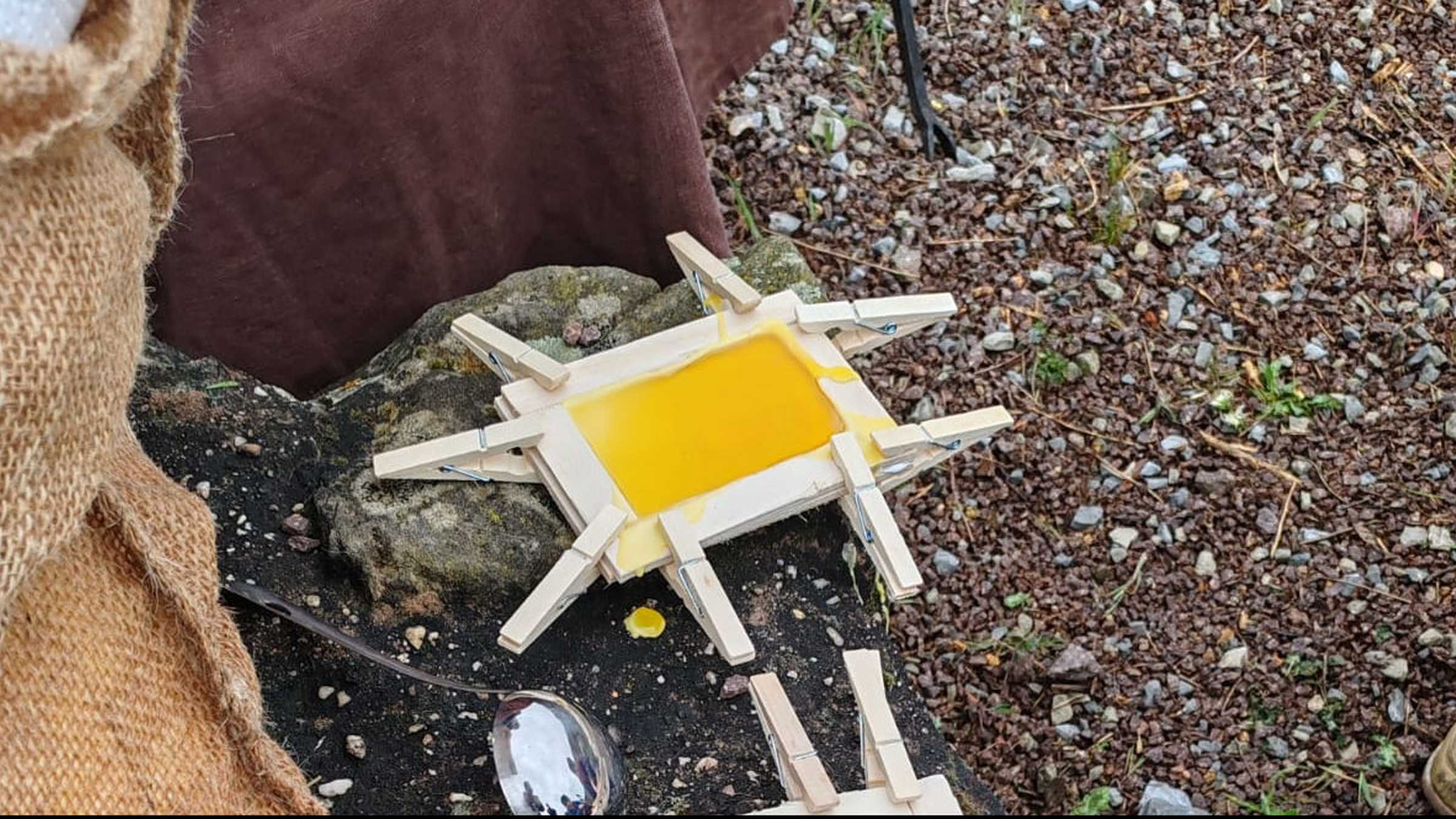 Wachstafel Holzrahmen mit Holzklammern fixiert, darin erhärtet gelber Bienenwachs