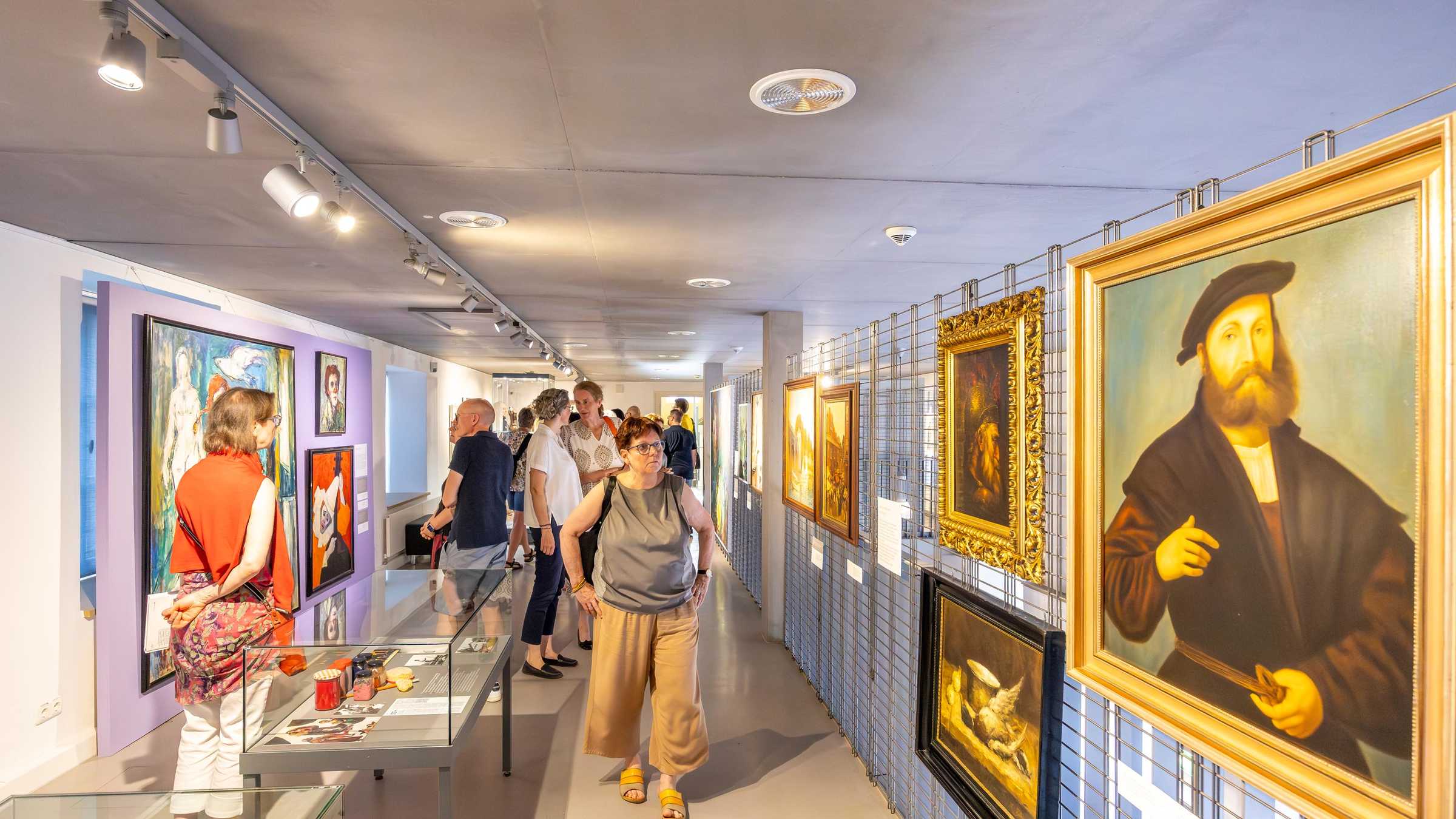 Blick in den Ausstellungsraum mit Menschen.