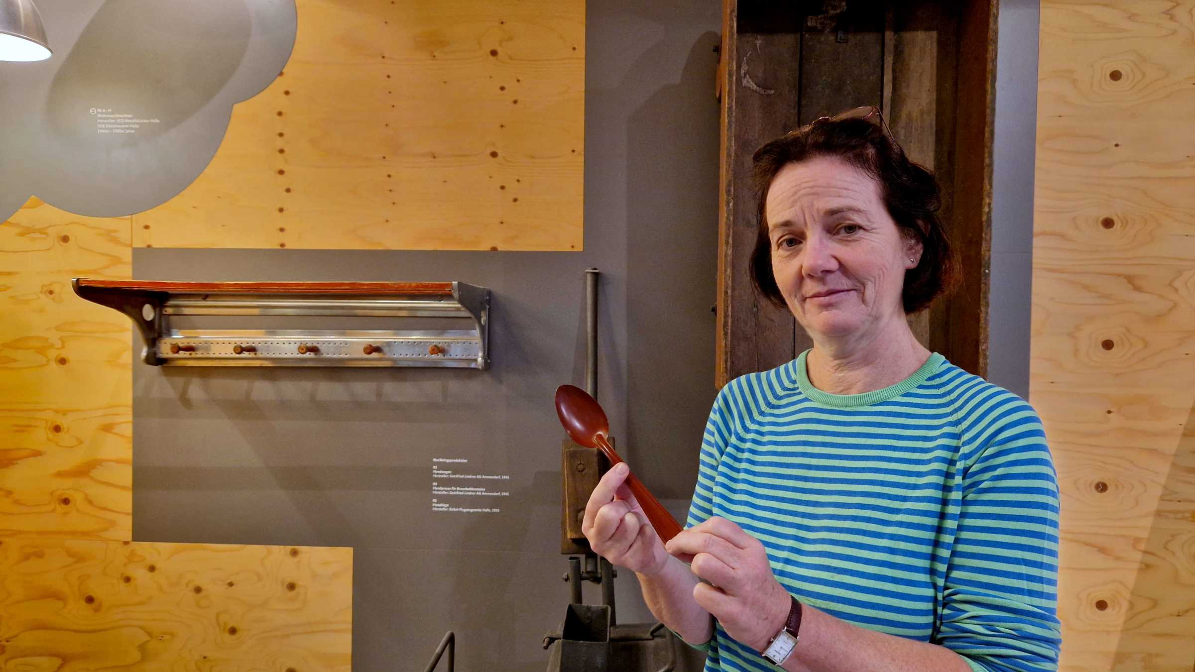 Ute fahrig mit einem emaillierten Löffel im Ausstellungsbereich "Made in Halle"