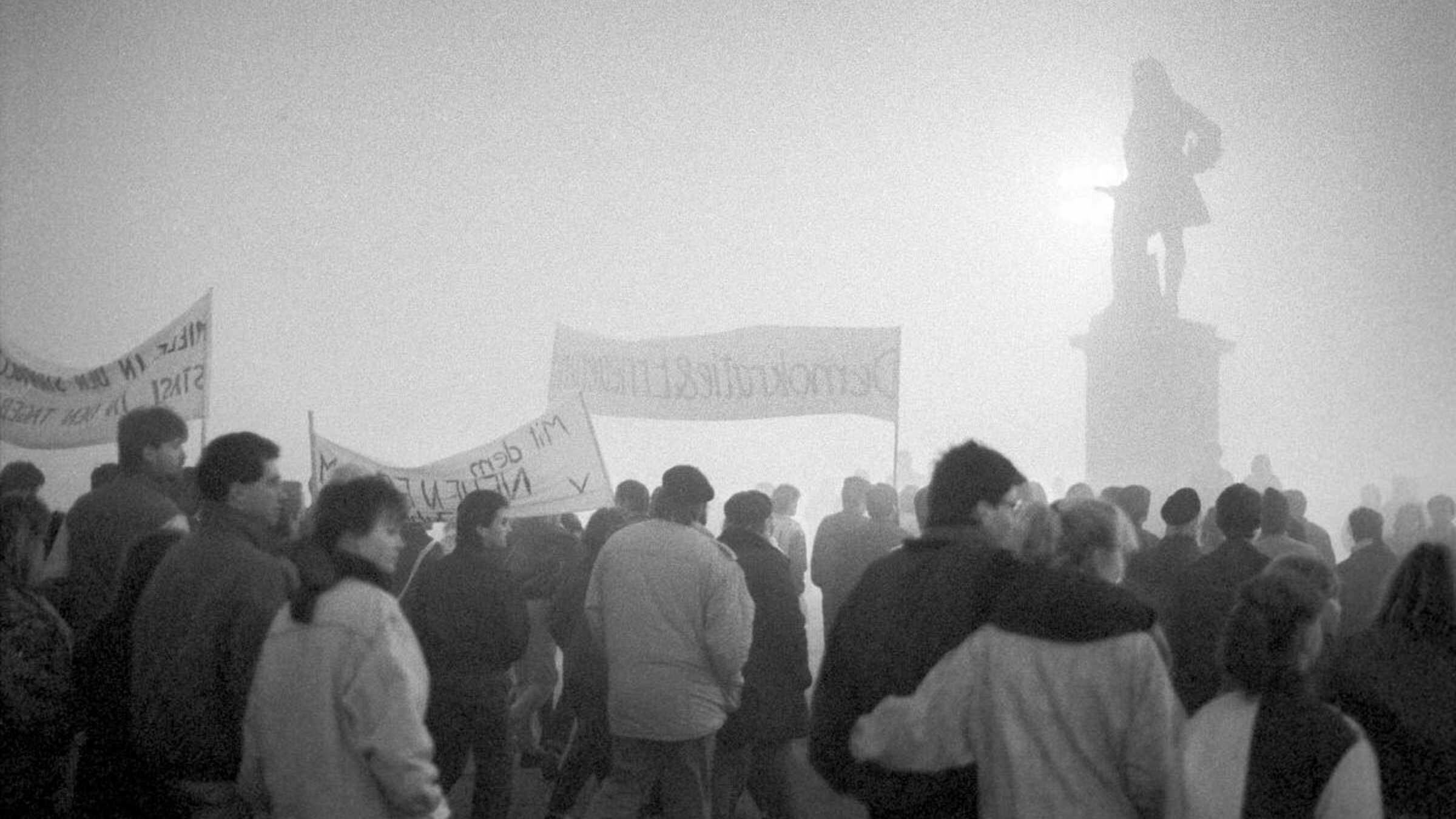 Menschen auf einer Demo im Nebel auf dem Marktplatz in Halle mit Händeldenkmal
