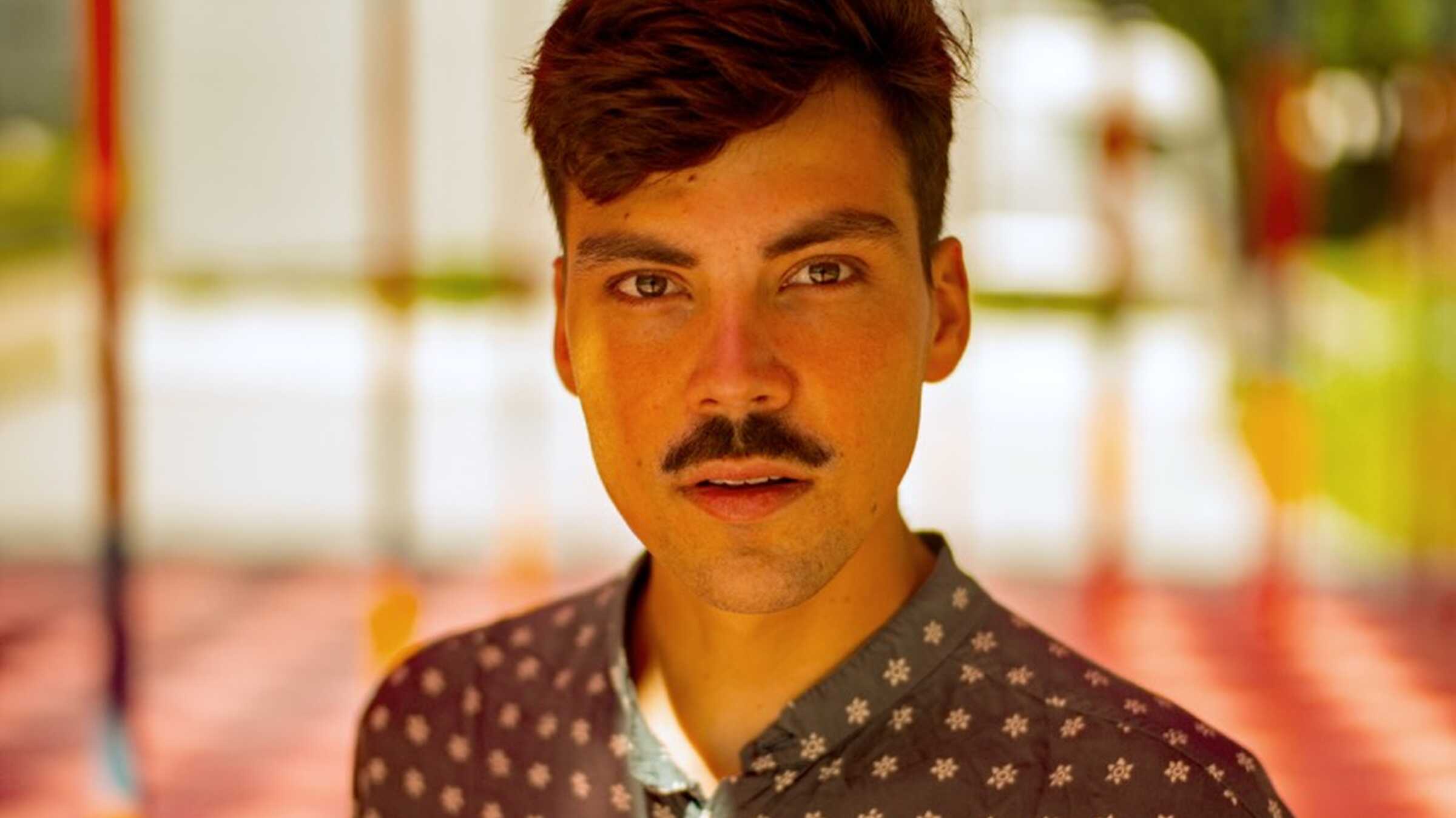 Aron Boks, ein junger Mann mit braunen Haaren und Schnurbart