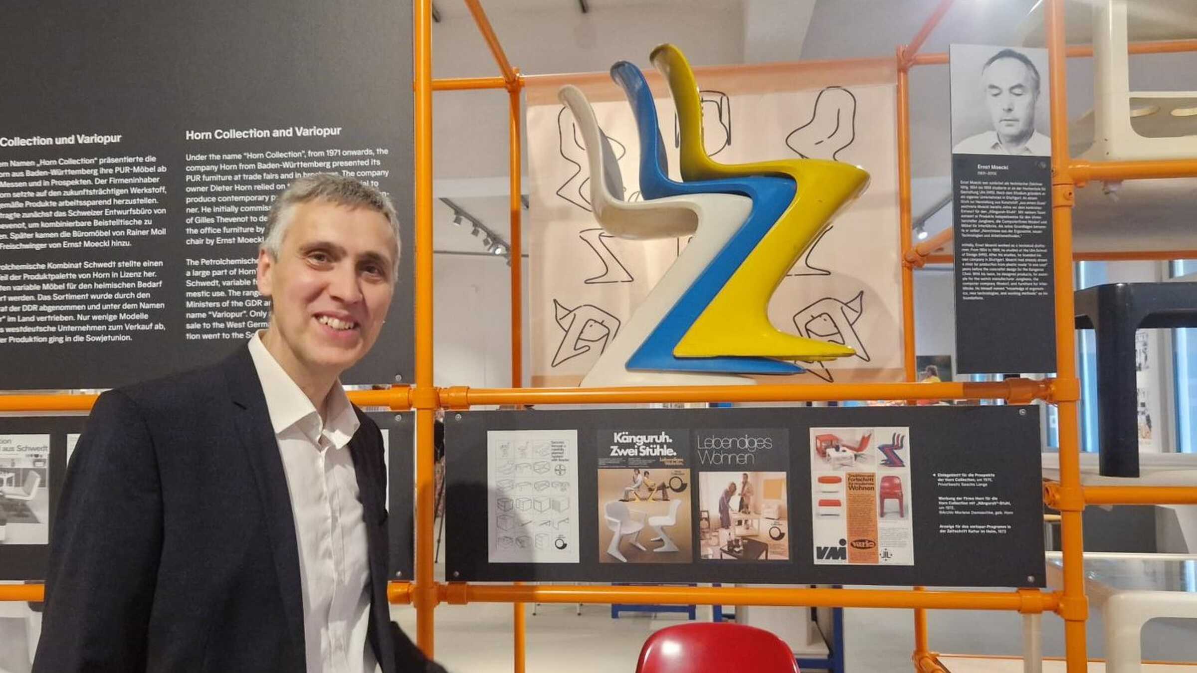 Axel Drieschner vor einem Ausstellungsregal mit Z-Stühlen