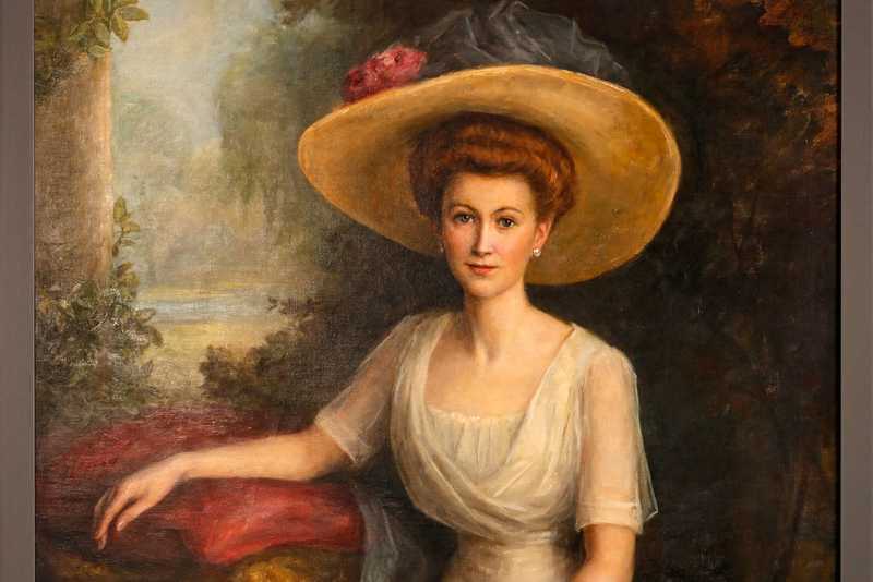 Charlotte Weihmann Portrait einer sitzenden schönen Frau im langen Kleid mit breitkrempigem Hut