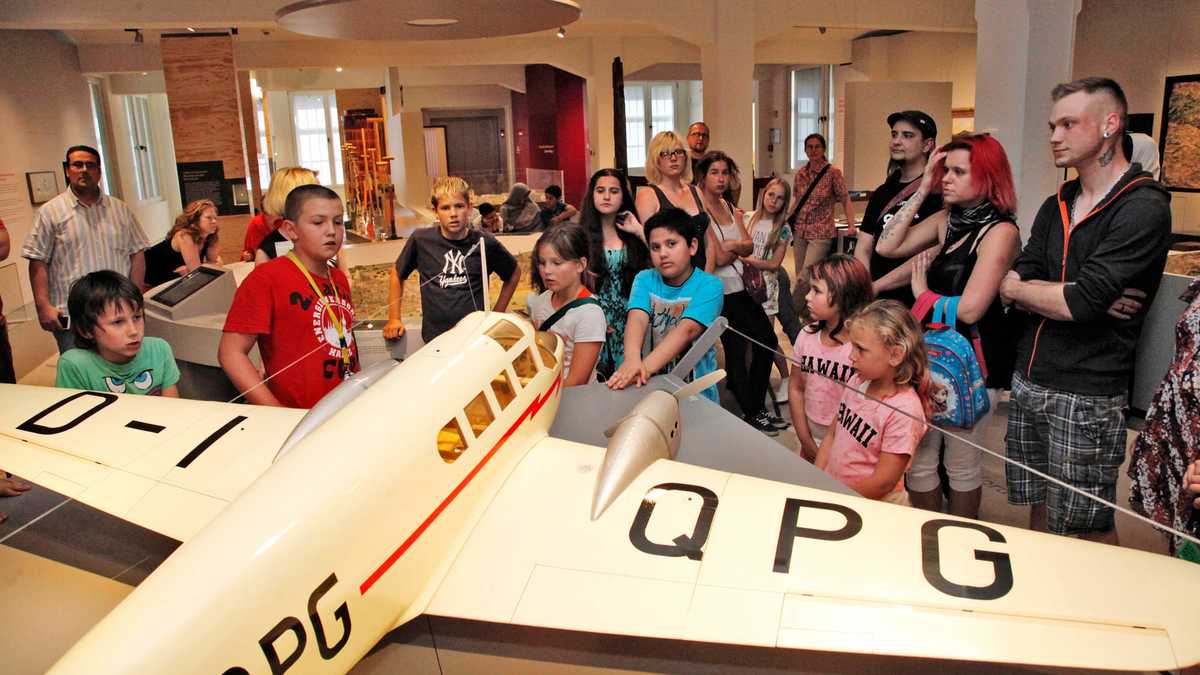 Blick auf das Modellflugzeug in der Ausstellung. Viele Kinder sehen sich das Flugzeug an.