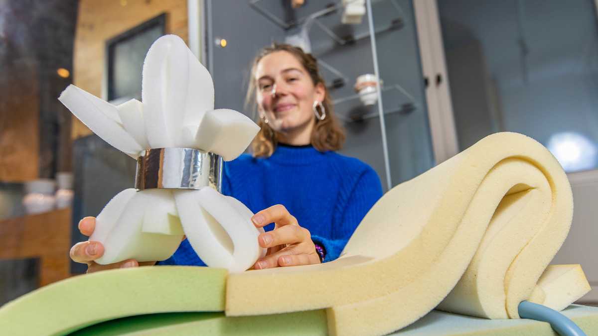 GiebichenStein-Designpreis für Marie Gehrhardt Preisträgerin Marie Gerhardt hält ihr Objekt in die Kamera: ein mehrfach gefalteter Schaumstoffstreifen, in der Mitte zusammengehalten von einem zylinderförmigen Hohlkörper.