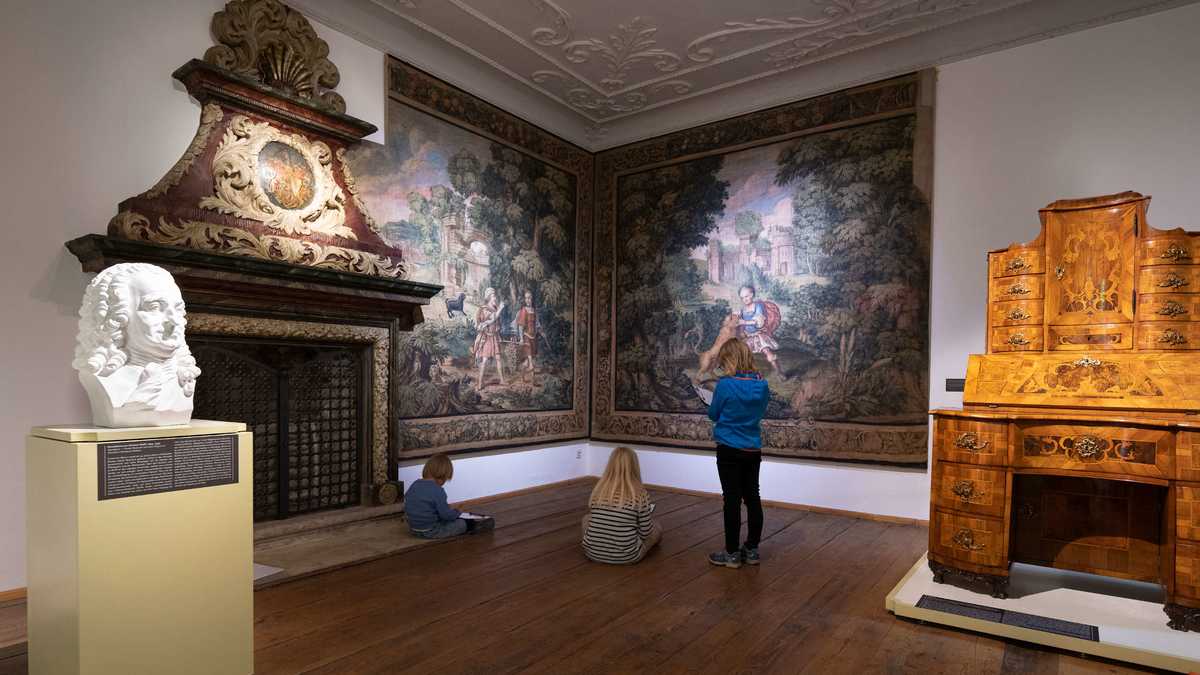 barockes Zimmer mit Motivtapeten, Stuck, Kamin, Schreibsekretär und Portraitbüste