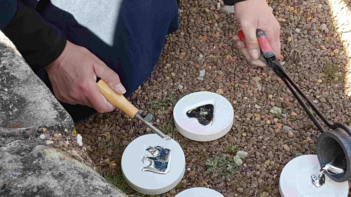 Person gießt Zinn in Gipsformen