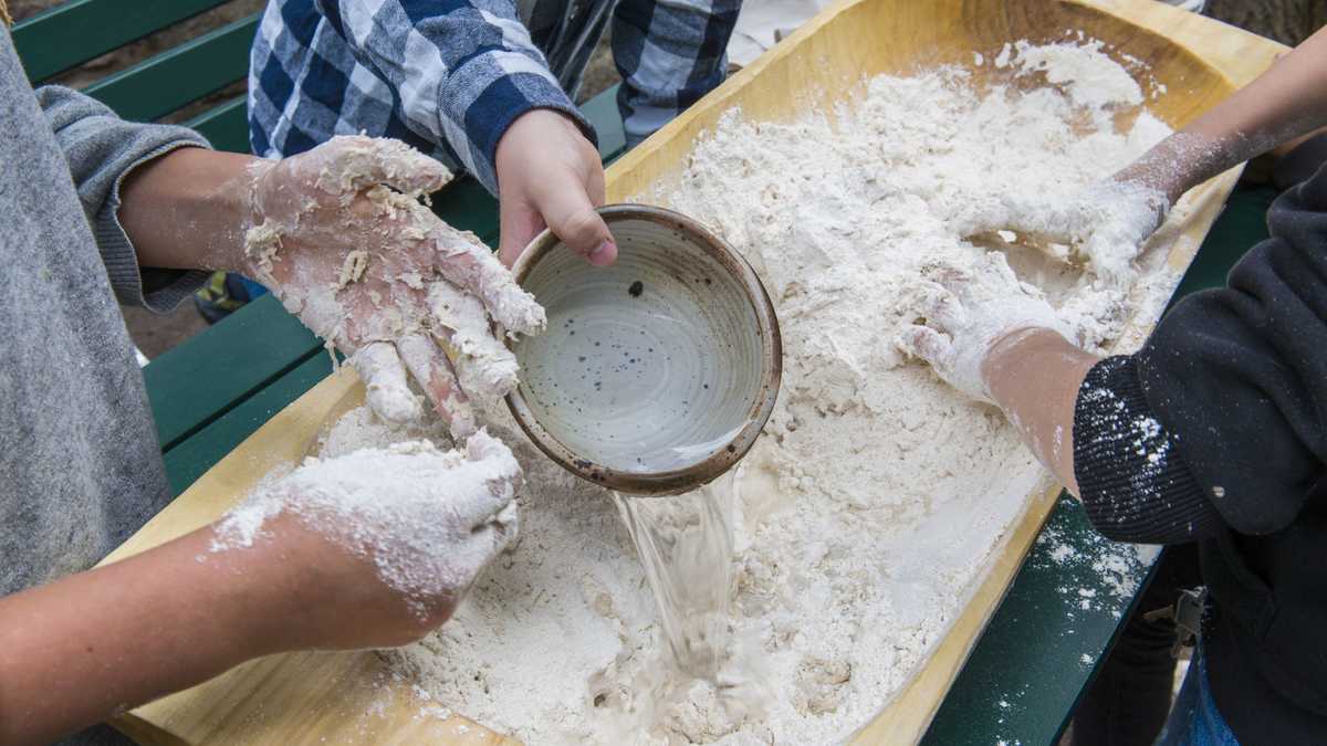 Vom Korn zum Brot Kinderhände verarbeiten Mehl und Wasser zu einem Brotteig