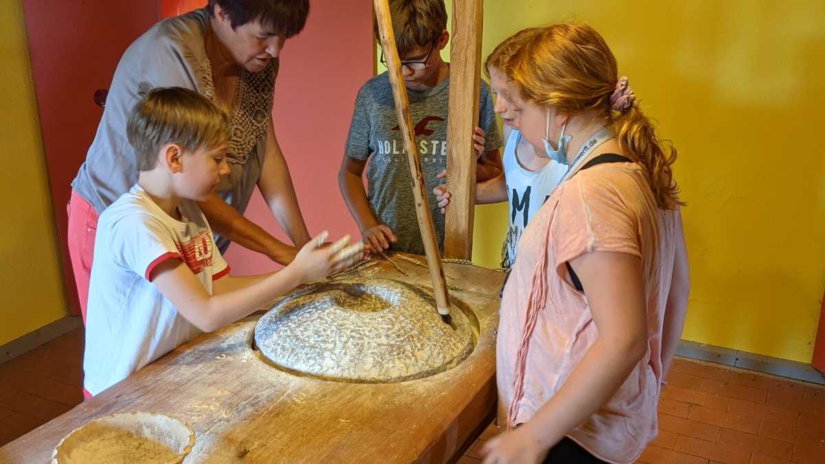 Kinder mahlen unter Anweisung ihr eigenes Mehl. Kinder mahlen unter Anweisung ihr eigenes Mehl.