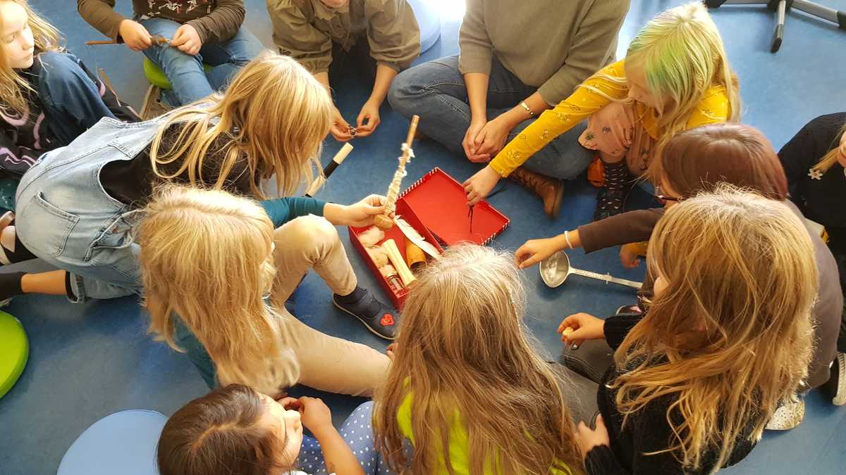 Schatzkiste Mädchen sitzen auf dem Fußboden um einen kleine Schatzkiste mit Mal- und Schreibuntensilien