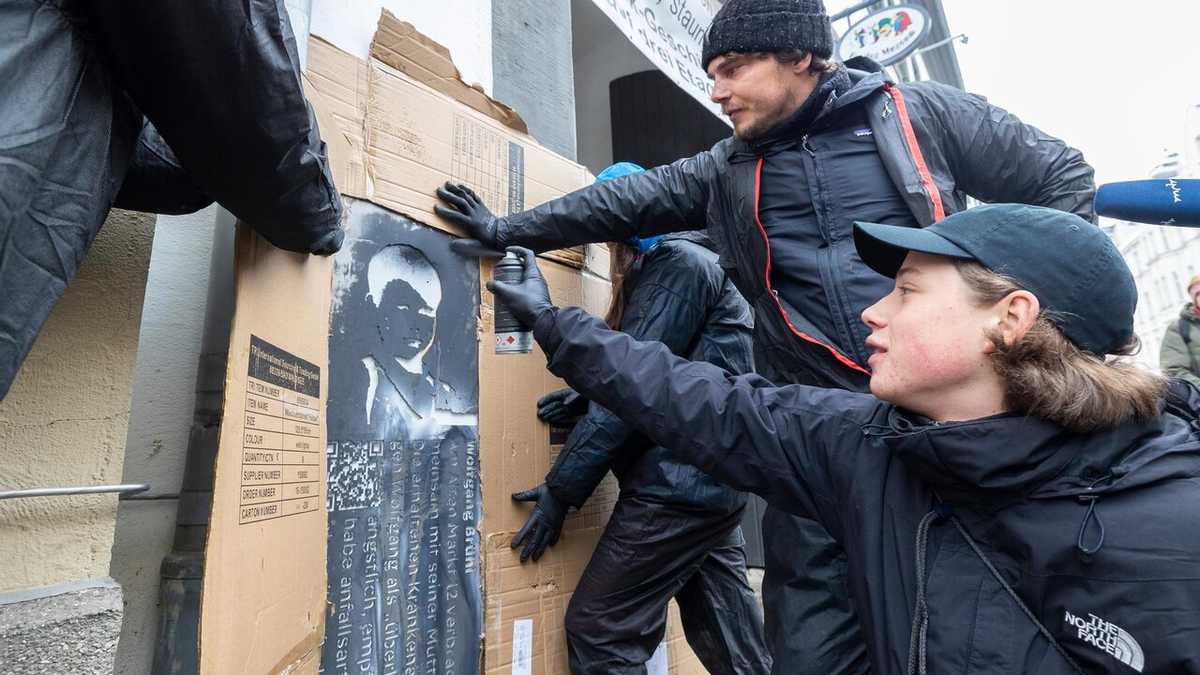 Das Grafitto wird mit Kreidespray aufgetragen. Künstler Victor Reichart und ein Jugendlicher beim Auftragen des Grafittos an der Hauswand