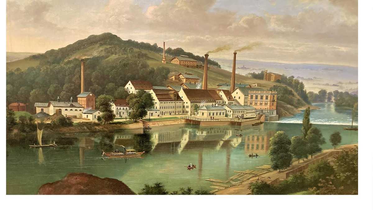 Häuser am Fluss vor einem Berg