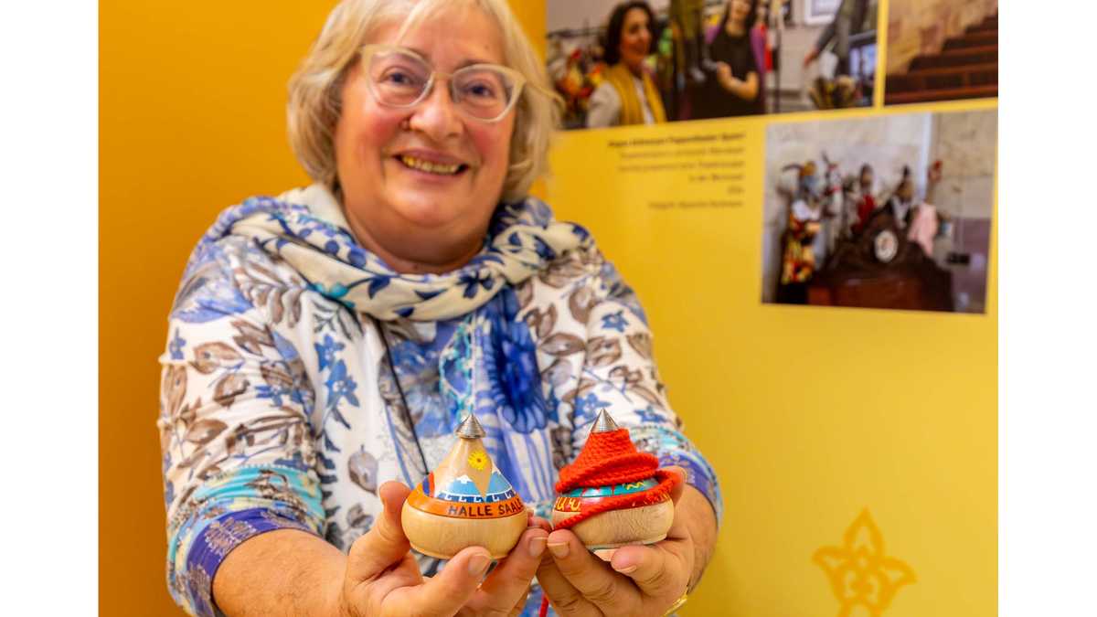 Armenuhi Drost-Abgarjan mit den traditionellen Wurfkreiseln "Hol" Frau Drost-Abgarjan hält lachend bemalte Wurfkreisel in die Kamera