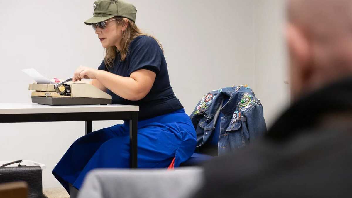 Figurenspielerin Julia Raab sitzt an einer Schreibmaschine.