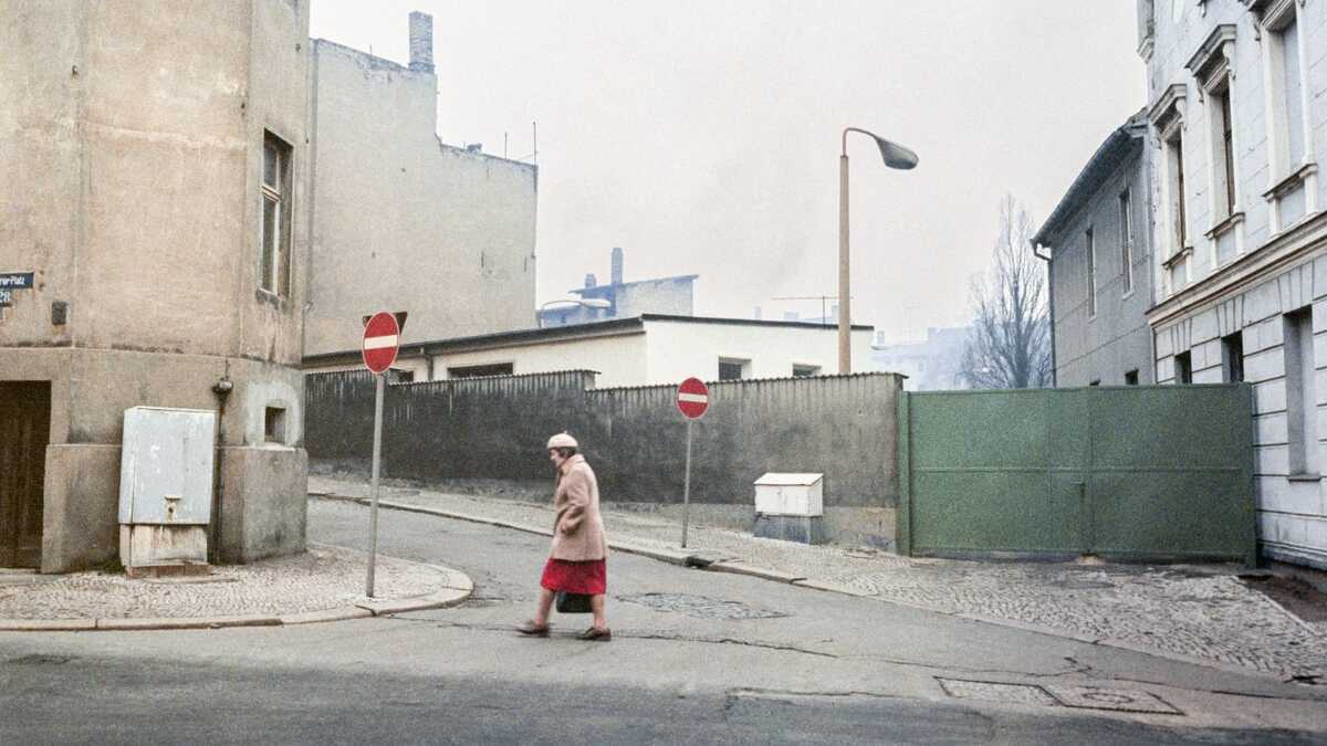 Die Farbfotografie von Reinhard Hentze ist vom Dezemeber 1987 und zeigt eine Frau, die die Marthastraße/August-Bebel-Straße  überquert. 
