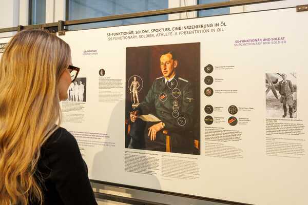 Eine Frau betrachtet die Ausstellung „Reinhard Heydrich. Karriere und Gewalt“