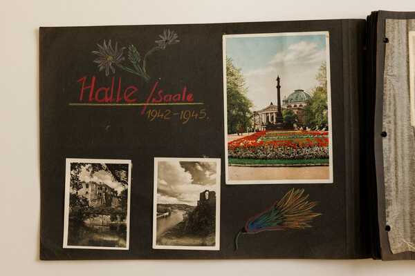 Fotoalbum mit schwarzen Seiten und Fotos von Sehenswürdigkeiten in Halle. Text mit Buntstift: Halle/Saale 1942-1945