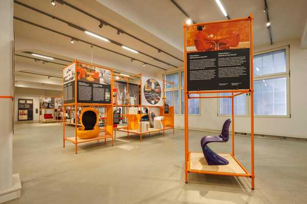 Blick in den Ausstellungsraum mit einem lila Pantone-Stuhl und weiteren Kunststoffmöbeln im Hintergrund