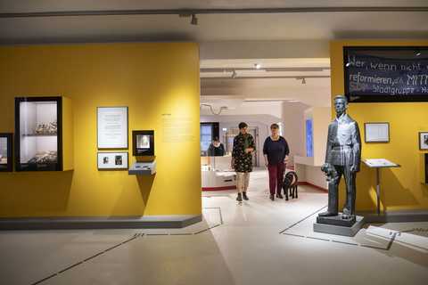 Entdecke Halle Blick in die Ausstellung und auf Frau mit einem Begleithund