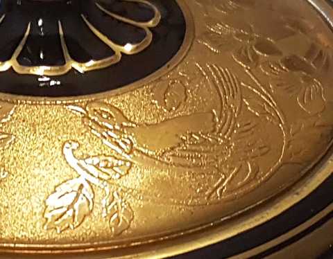 Goldverzierung Detail Deckel mit geätztem Goldmotiv in Form eines Vogels