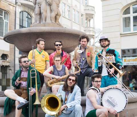 Dr. Donner Die Mitglieder der Band "Dr. Donner" mit Instrumenten vor einem Brunnen