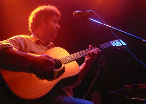 Southbound Scotti mit Gitarre und Mikrofon auf der Bühne im Scheinwerferlicht