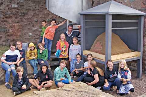 Die Kinder des Projekts posieren stolz mit ihrem selbstgebauten Lehmofen Die Kinder des Projekts posieren auf der Burg Giebichenstein. Rechts von ihnen ist der fertige Lehmofen in seiner Überdachung zu sehen.
