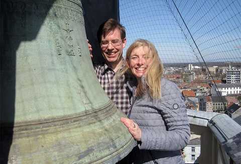 Georg Wagner und Ariane Toffel CC: Christian Michel Georg Wagner und Ariane Toffel stehen an einer großen Glocke auf einem Glockenturm